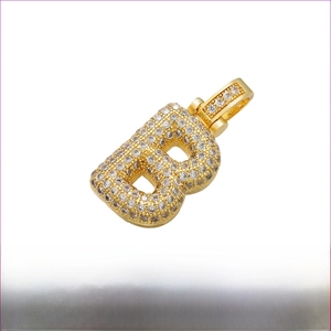 Macro shot of gold plated hip hop letter B pendant with micro paved cubic zirconia