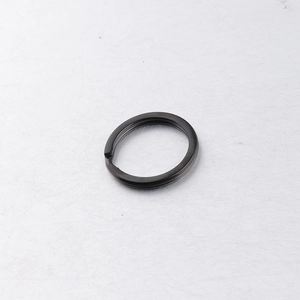 Close-up of a premium black stainless steel flat key ring on a metallic surface