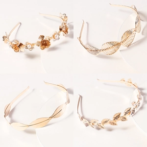 Golden flower and leaf metal headband set with pearl accents on a white display