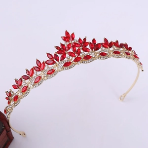 Detailed view of bridal crown featuring red marquise crystals and golden leaf accents