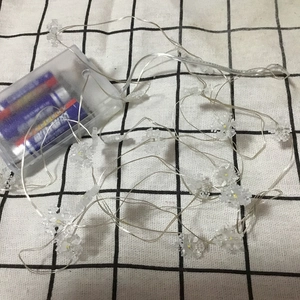 Detail of snowflake LED string lights with transparent battery box on checkered cloth