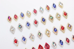 Detailed view of colorful marquise crystal nail charms with rhinestones in golden and silver settings