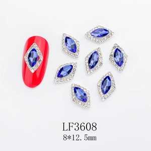Detail of horse-eye blue nail crystal LF3608 with silver trim on red manicure base