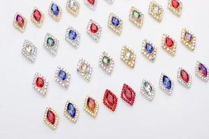 Close-up of diamond-shaped alloy nail charms with colorful crystals and rhinestones