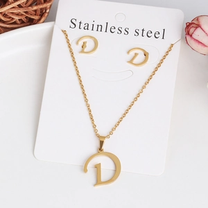 Detail of gold stainless steel jewelry set featuring a letter D pendant and earrings
