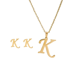 Detail of gold stainless steel necklace and earrings set featuring letter K pendant design