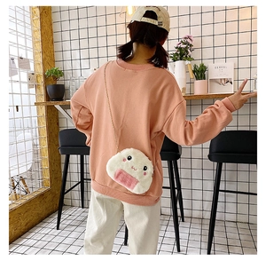 Onigiri-shaped plush crossbody bag with embroidery and gold chain shown on a model