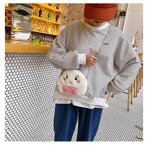 Detail shot of cute white onigiri plush bag with pink accents and golden metal chain strap