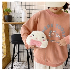 Girl wearing the cute plush rice ball bag with pink details and gold metal chain strap