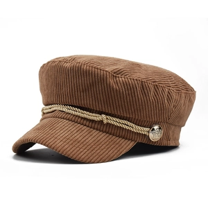 Detail of caramel corduroy baker boy hat with gold braided rope and metallic buttons