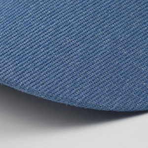 Detailed macro view of the blue corduroy fabric texture on the octagonal newsboy cap