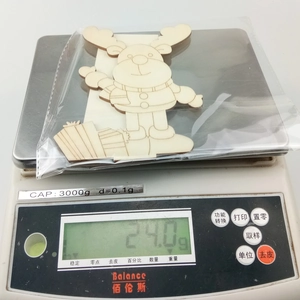 DIY wooden Santa reindeer decoration on electronic scale showing weight of 24.0g