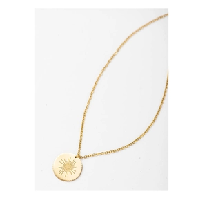 Detailed view of golden sunburst evil eye medallion pendant on a fine link chain necklace
