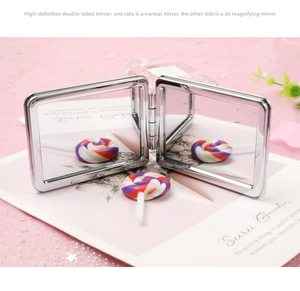 Detail of portable folding makeup mirror featuring 1x and 2x magnification surfaces