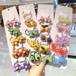 Close-up of colorful cartoon hair ties including dinosaur and flower shapes for girls