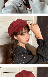 Detail shot of a dark red faux suede newsboy hat worn by a model from a side profile