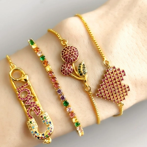 Detail of four-piece gold bracelet set with colorful zircon cherry and heart charms