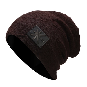 Detailed knit texture of burgundy beanie with black square patch and star emblem