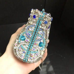 Detail of owl clutch bag with blue crystals and intricate hollow metal framework