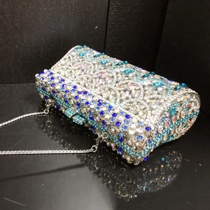Macro shot of luxury silver evening clutch with blue rhinestone scales and chain detail