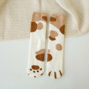 Close-up of plush coral fleece cat claw socks in cream white with soft brown patterns