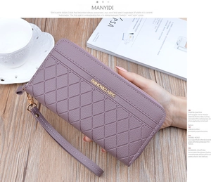 Detailed view of lavender quilted leather wallet with gold emblem and detachable wrist strap