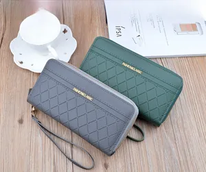 Detailed view of long plaid wallets with double zippers and wristlet in gray and green