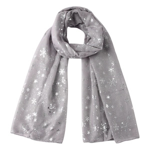 Détail d'une écharpe en coton gris avec des motifs de flocons de neige argentés brillants