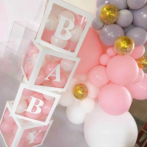 Close-up of four transparent BABY letter boxes filled with pink and white party balloons