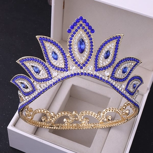 Detail of baroque gold bridal crown with blue and white rhinestones on dark background