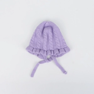 Detail of baby knit hat in light purple featuring cable stitch pattern and ruffle edge