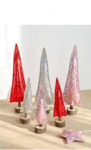 Detail of glittered red silver and pink mini wooden Christmas trees on round log bases