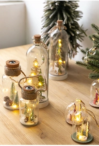 Detail of Christmas LED glass jars with miniature snow scenes and warm holiday lighting
