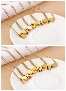 Close-up of gold heart and alphabet charms E to N on a sleek box chain necklace