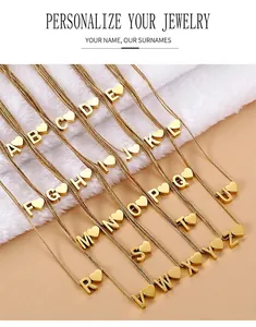 Detailaufnahme von 26 goldenen Herz-Buchstabenketten auf weichem Kunstfell-Hintergrund