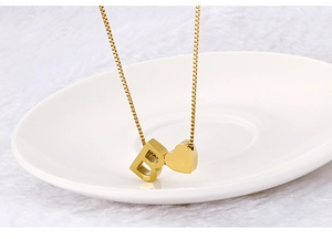 Macro shot of gold-plated stainless steel letter B and heart pendant necklace