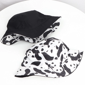 Detail of reversible bucket hats featuring cute black and white panda print and solid black