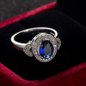 Close-up of sapphire blue oval zircon ring presented in a red velvet jewelry gift box