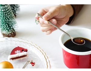 Detailed close-up of a silver Christmas coffee spoon with festive enamel wreath pendant