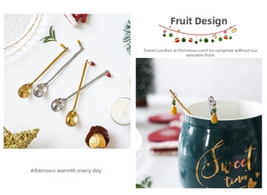 Detail of Christmas stainless steel spoons with fruit charms on a mug rim