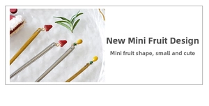 Detailed view of stainless steel dessert picks with mini strawberry and pineapple pendants
