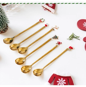 Detailed view of six golden Christmas themed spoons with Santa and tree decorative charms