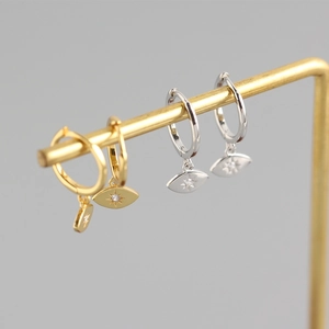 Macro detail of gold and silver S925 sterling silver eye-shaped drop earrings