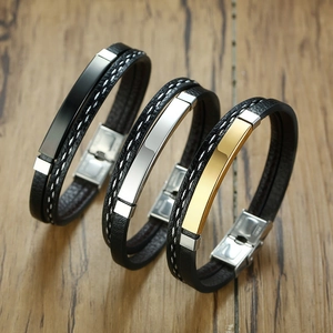 Three men's braided leather bracelets with polished metal plates in black, silver, and gold