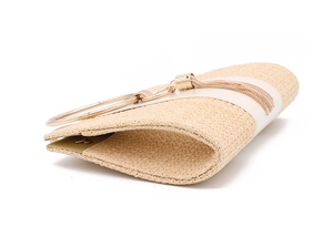 Detail of beige straw clutch bag featuring a gold round metal handle and tassel