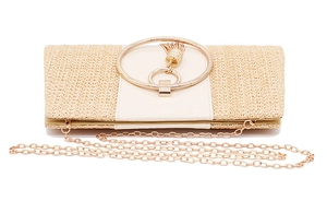 Detail of straw woven evening clutch with gold circular handle and tassel ornament