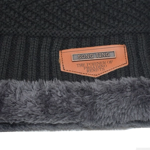 Black knit beanie with thick fleece lining and shield leather patch for winter warmth
