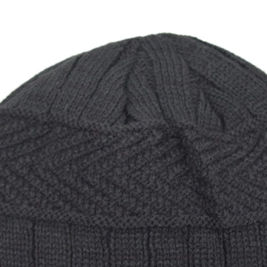 Close-up of black cable knit beanie showing thick ribbed texture and warm winter material