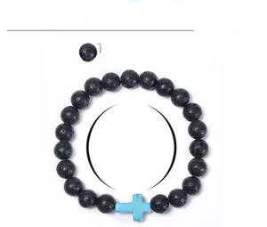 Macro detail of 8mm black lava stone beads and blue turquoise cross charm bracelet