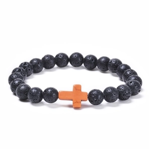 Close-up of black lava rock beads and orange turquoise cross on beaded bracelet